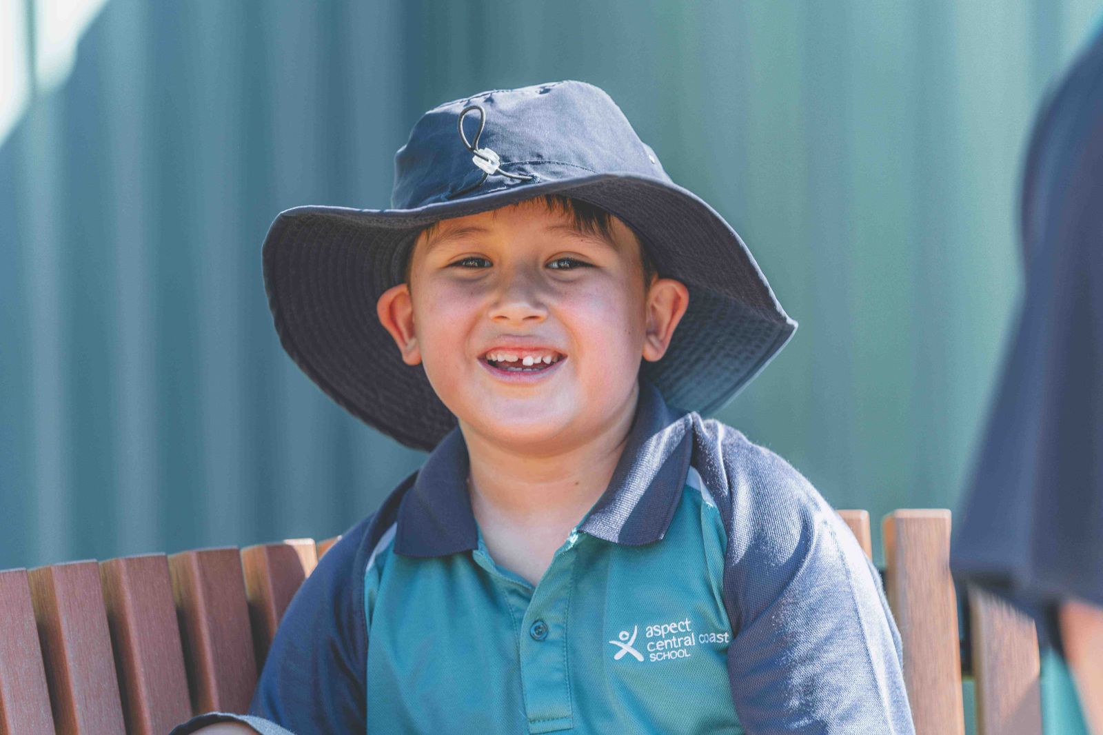 Student smiling outdoors wearing school hat
